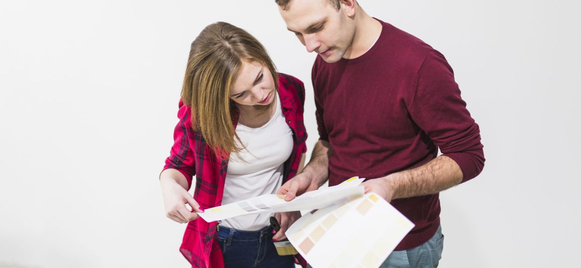 couple-looking-paper-with-paint-samples