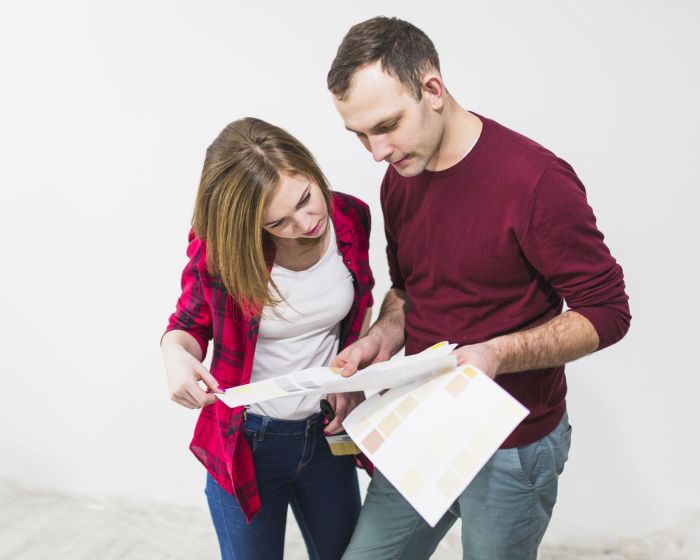 couple-looking-paper-with-paint-samples